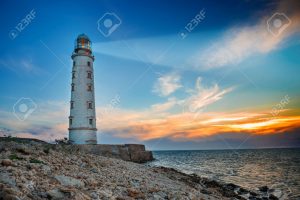 39704848-lighthouse-searchlight-beam-through-sea-air-at-night-seascape-at-sunset-stock-photo